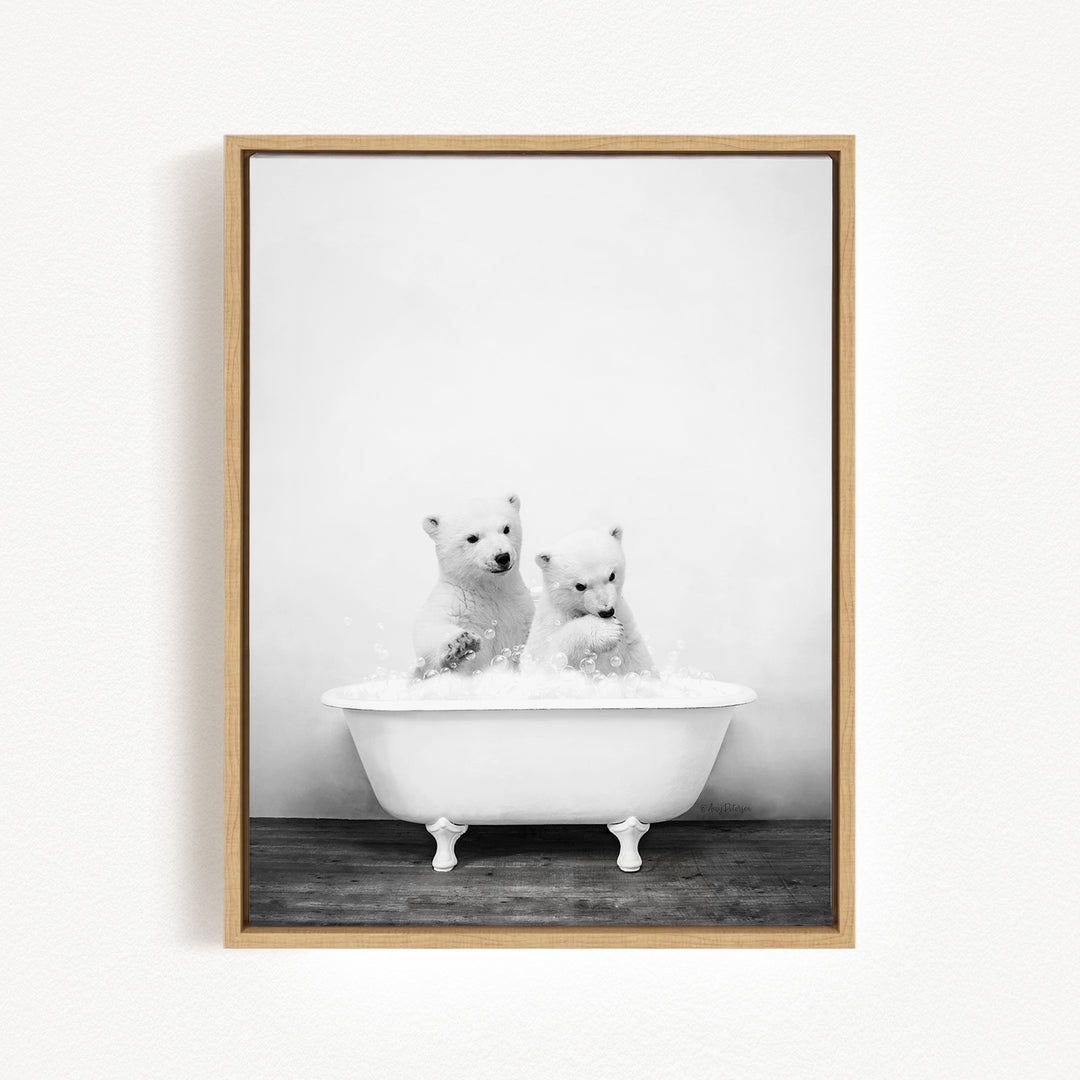 Two adorable polar bears enjoying a bath in a white bathtub.