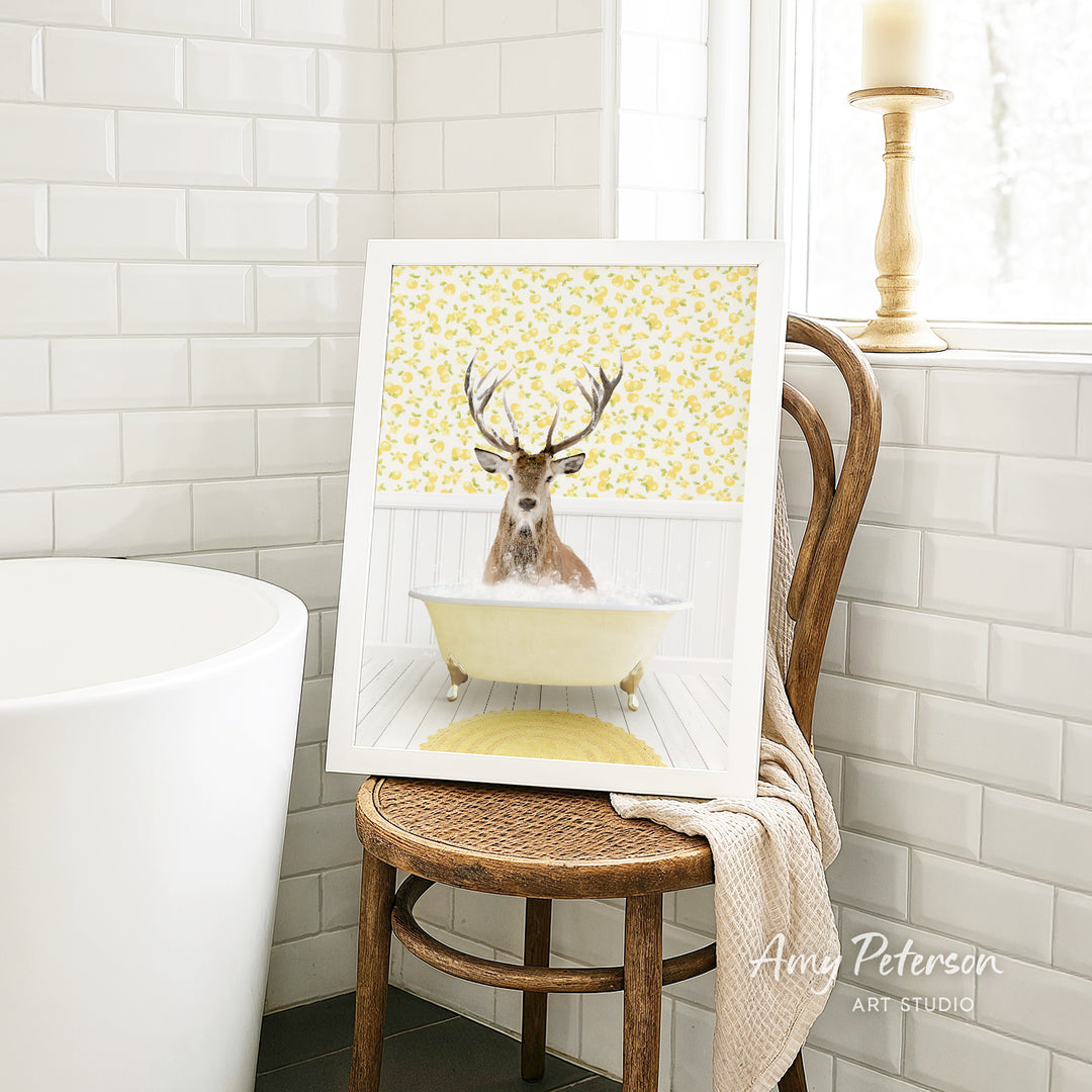 A framed image of a deer with antlers sitting in a bathtub, surrounded by a yellow floral pattern.