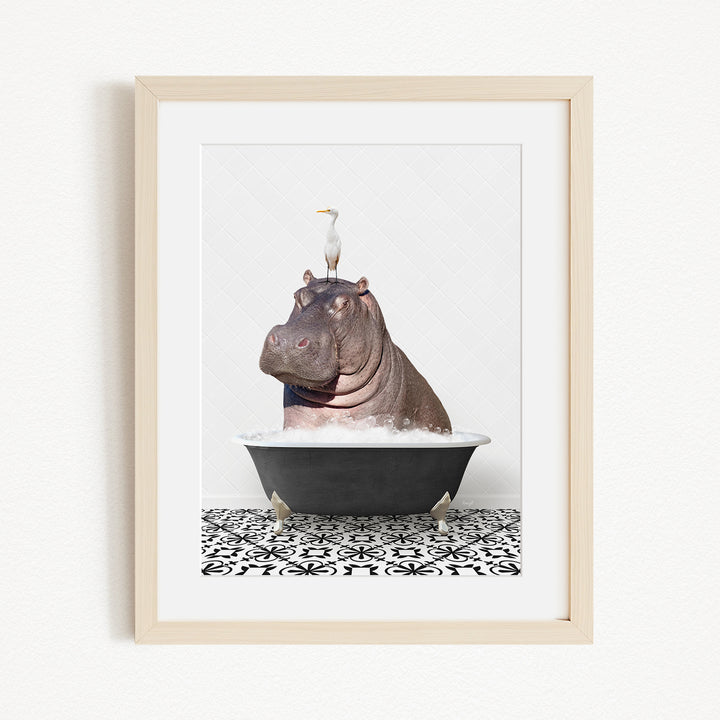 A framed image depicting a large hippopotamus sitting in a bathtub, with a seagull perched on its head.
