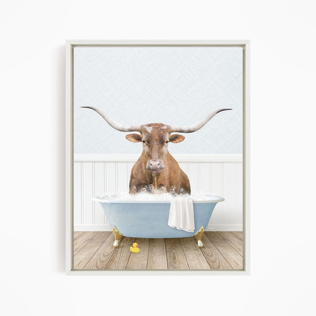 A brown cow with long horns is sitting in a blue bathtub filled with water, surrounded by rubber ducks.