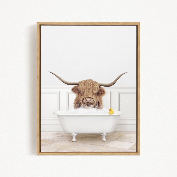 A long-haired cow with large horns is sitting in a white bathtub, surrounded by a yellow rubber duck.