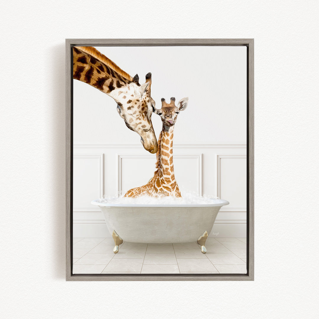 A mother giraffe and her baby giraffe are sitting together in a white bathtub, with the mother gently licking her baby.