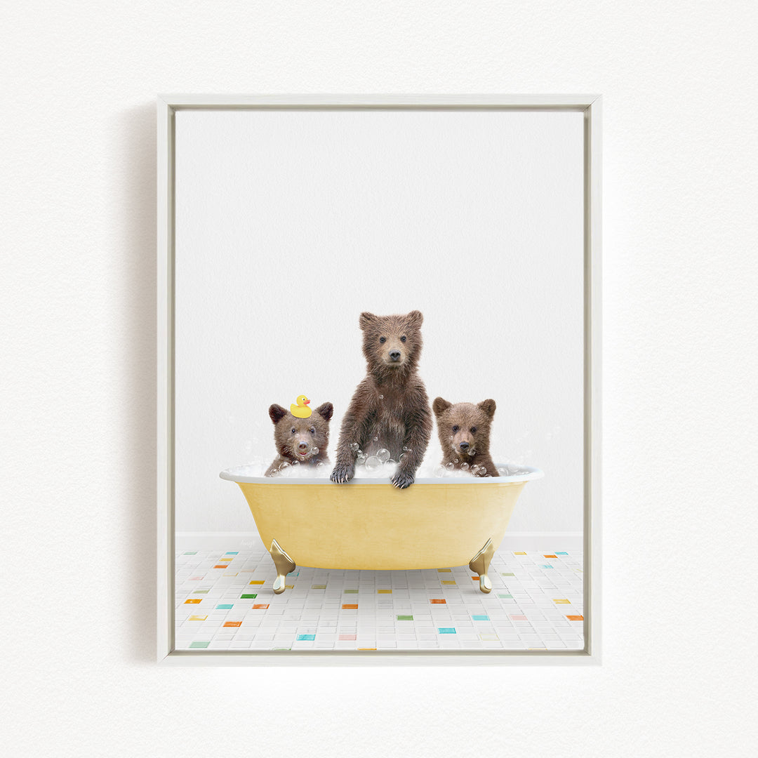 Three adorable brown bears sitting in a yellow bathtub filled with water, with one bear wearing a yellow hat.