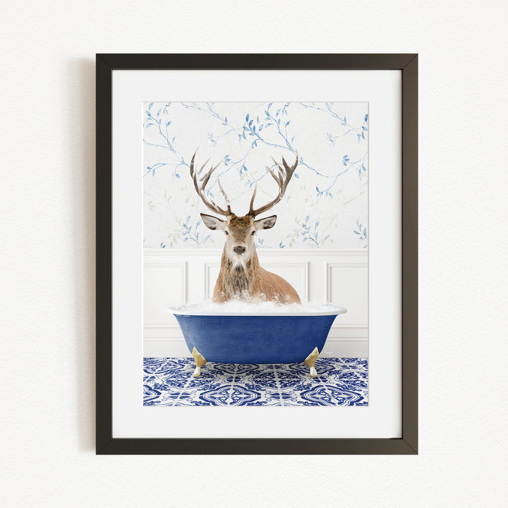 A deer with large antlers is sitting in a blue bathtub filled with water, surrounded by a patterned tile floor.