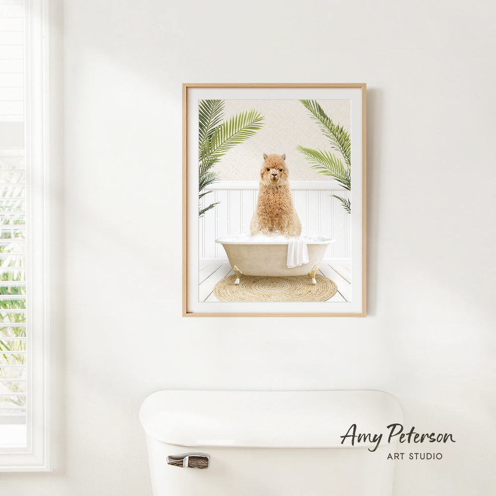 A framed image of a dog sitting in a bathtub, surrounded by palm leaves, is hanging on a white wall in a bathroom.