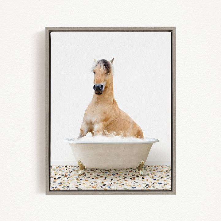 A light brown horse is sitting in a white bathtub filled with water, creating a whimsical and playful scene.