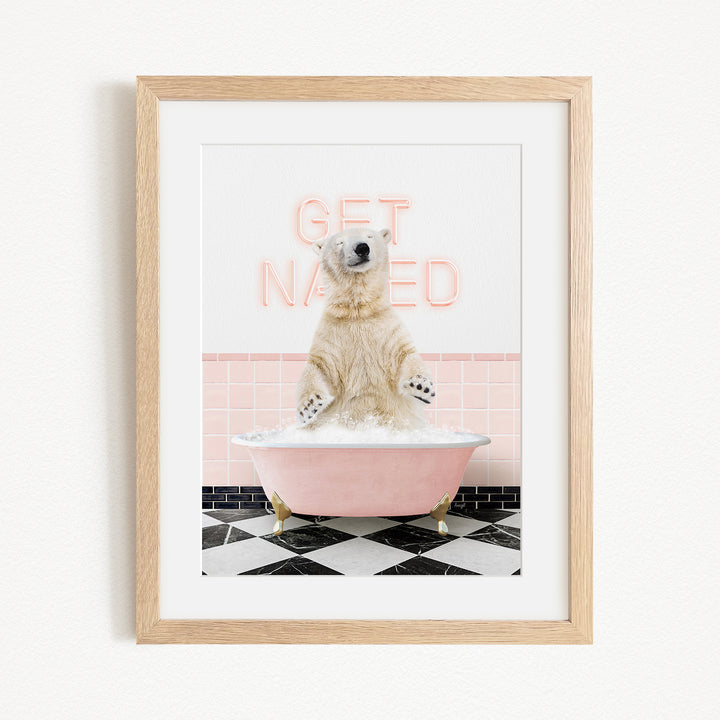 A polar bear sitting in a pink bathtub with the words "GET NAKED" written on the wall behind it.