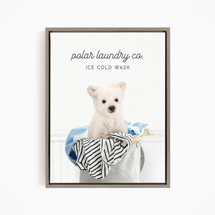 A white polar bear sitting in a laundry basket filled with clothes, with the text "polar laundry co. ICE COLD WASH" displayed above the image.