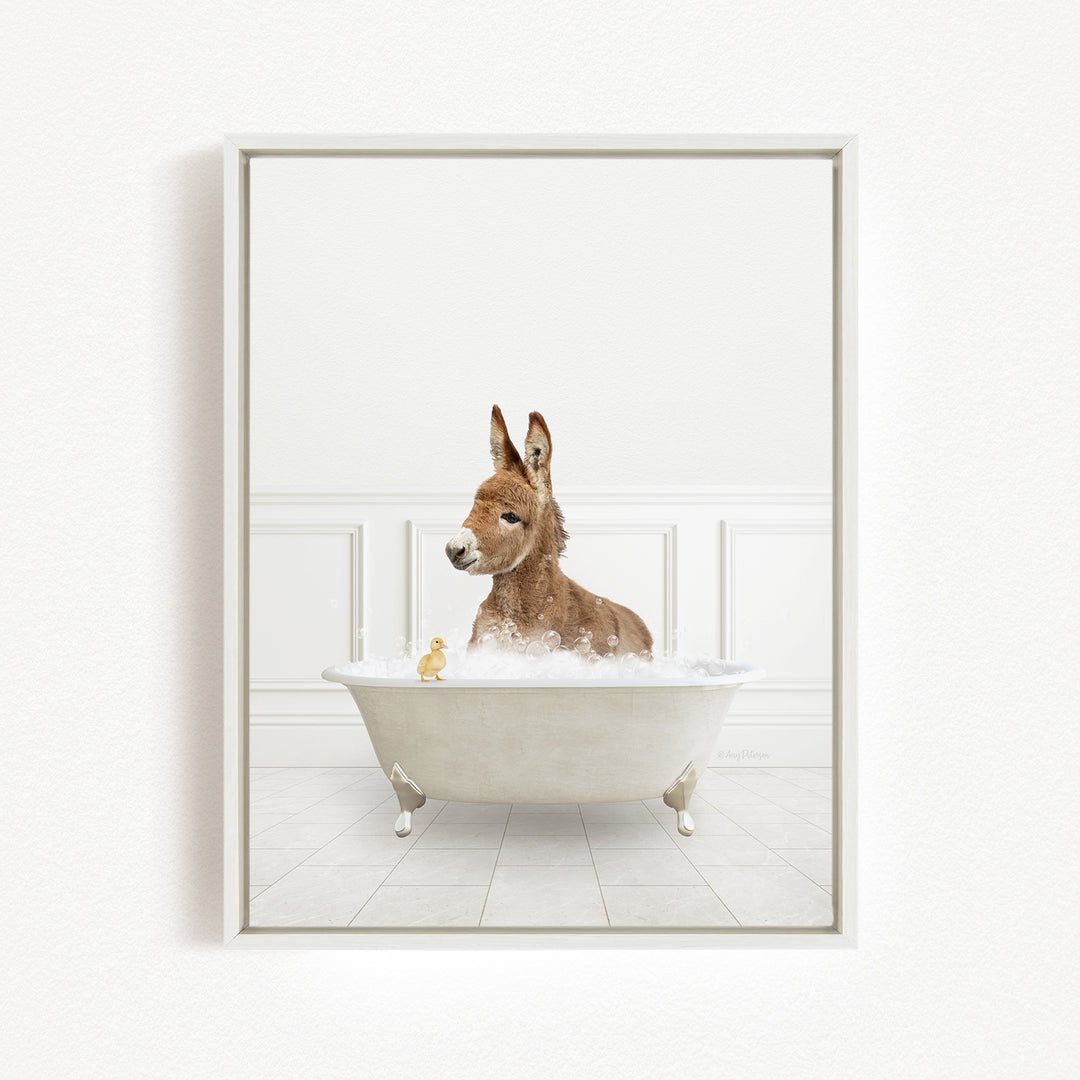 A donkey is sitting in a bathtub filled with bubbles, surrounded by a few rubber ducks.