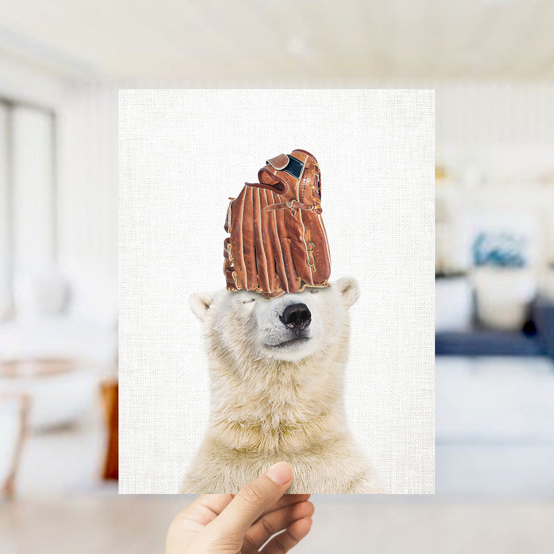A polar bear wearing a baseball glove on its head, with a blurred background suggesting a room setting.