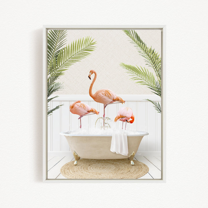 A framed image depicting three flamingos standing in a bathtub filled with water, surrounded by green palm leaves.