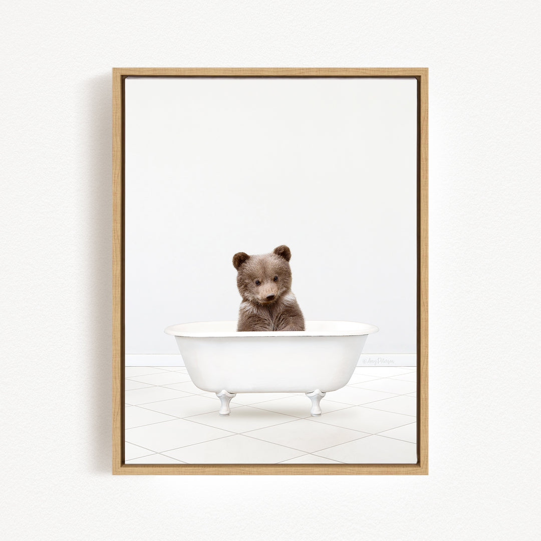 A brown bear sitting in a white bathtub against a white background.