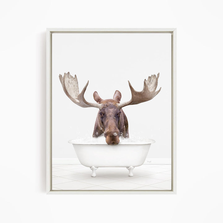 A moose with large antlers is sitting in a white bathtub filled with water, creating a whimsical and humorous scene.