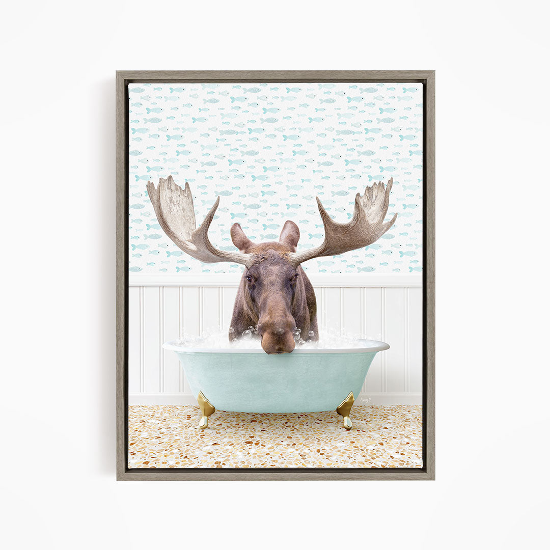 A moose with large antlers is sitting in a light blue bathtub filled with water, surrounded by a pattern of fish.