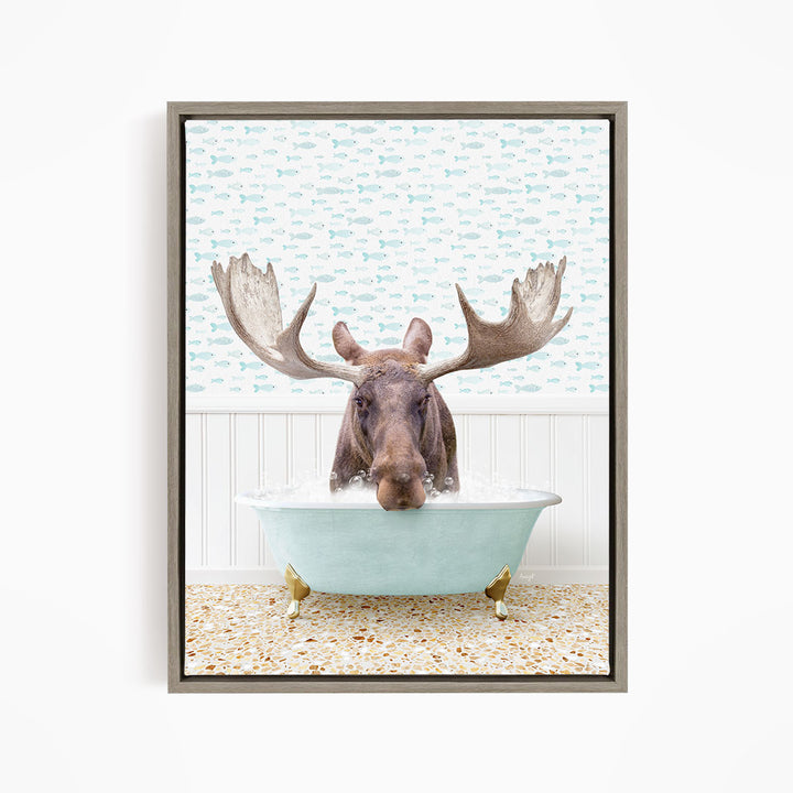 A moose with large antlers is sitting in a light blue bathtub filled with water, surrounded by a pattern of fish.