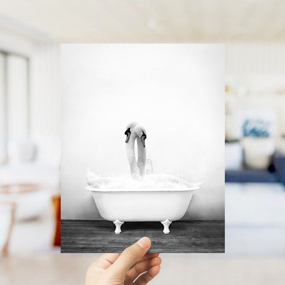 A hand holds up a photograph of a swan standing in a bathtub filled with water, creating a visually striking image.