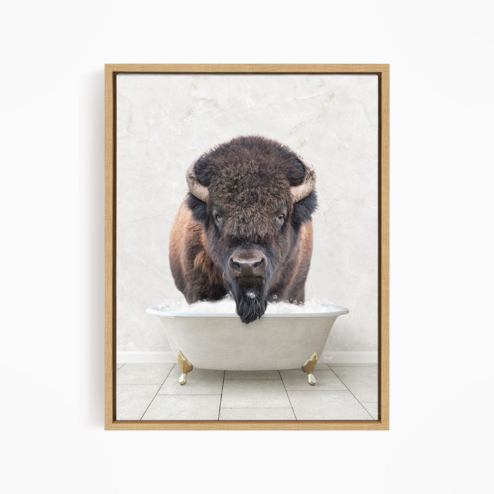 A buffalo with large horns is standing in a white bathtub, appearing to be enjoying a bath.
