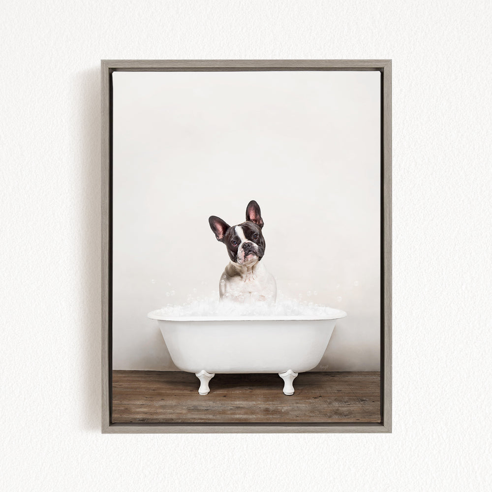 A dog is sitting in a white bathtub filled with bubbles, looking directly at the camera with a curious expression.