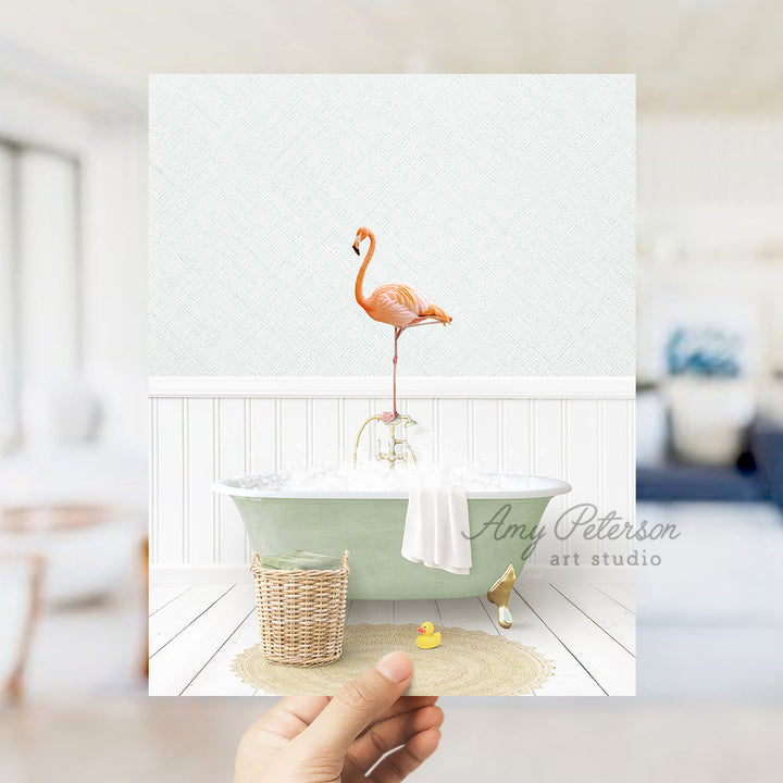 a person holding up a card with a flamingo in a bathtub