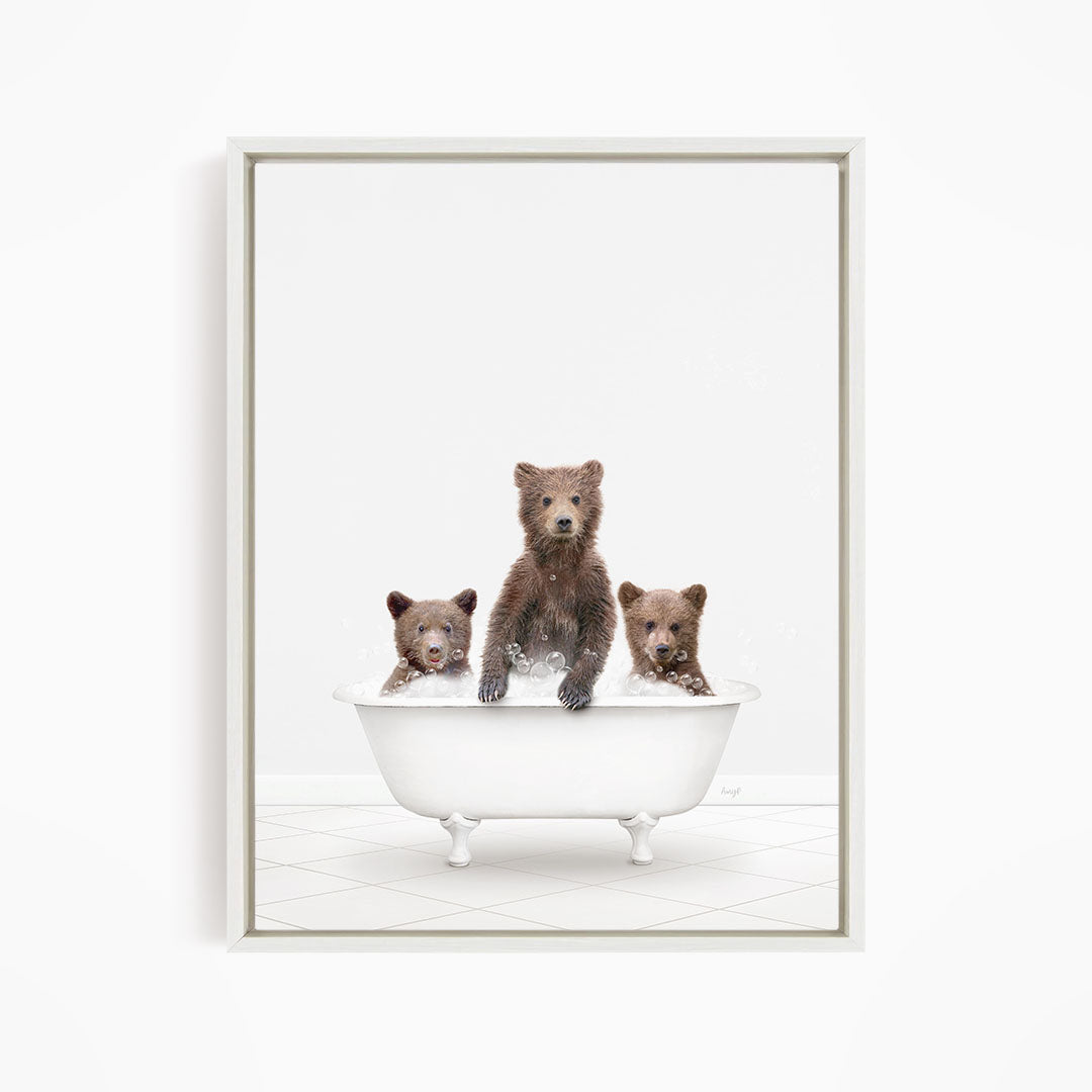 A white bathtub filled with water, containing three brown bears of different sizes.
