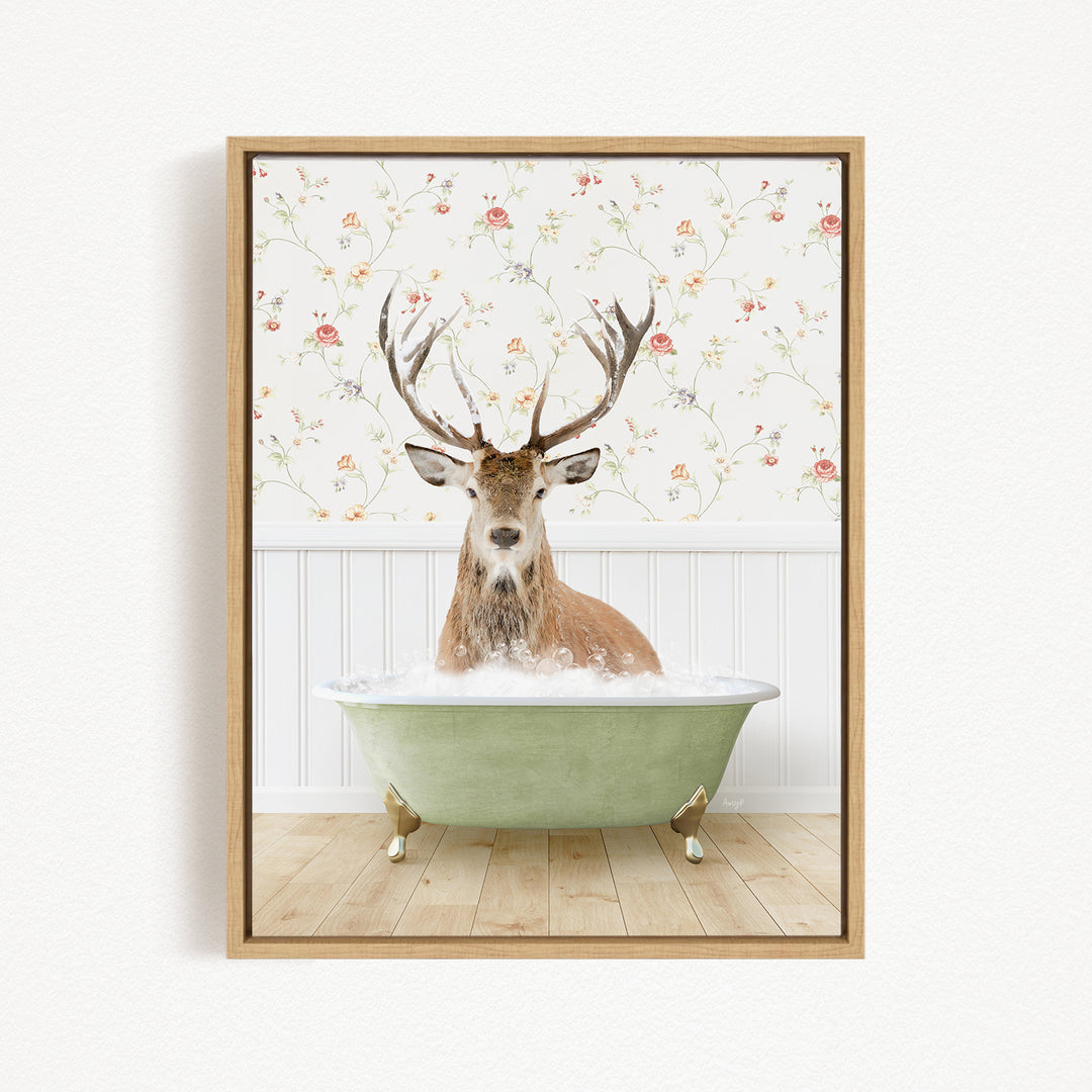 A deer with large antlers is sitting in a green bathtub filled with water, surrounded by a floral wallpaper.