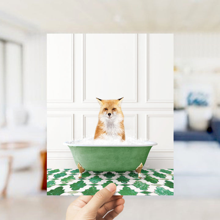 A small orange fox is sitting in a green bathtub filled with bubbles, looking directly at the camera.