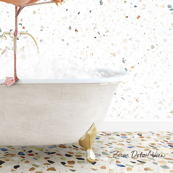 A white clawfoot bathtub filled with water, with a colorful mosaic floor in the foreground.