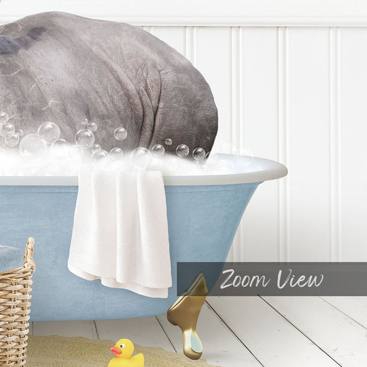 A large gray elephant is sitting in a blue bathtub filled with bubbles, surrounded by a yellow rubber duck and a white towel.