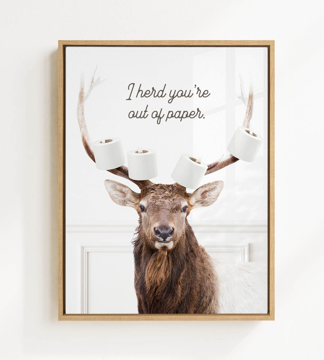 A deer with antlers holding multiple rolls of toilet paper, with the text "I herd you're out of paper" above the deer.