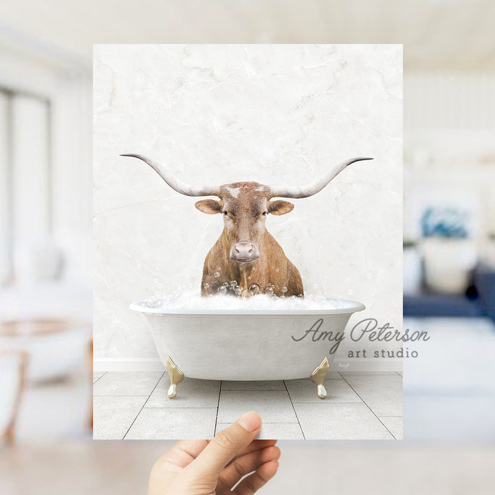 a hand holding up a photo of a bull in a bathtub