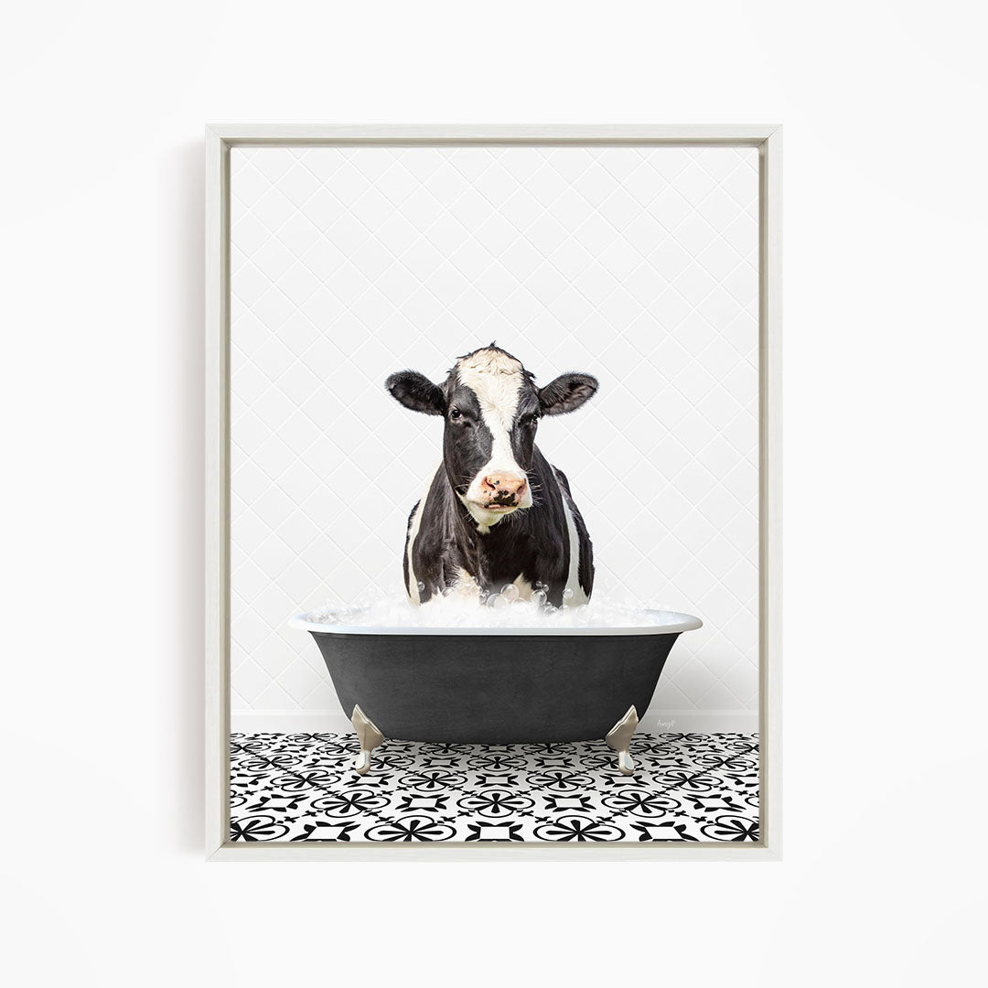 A black and white cow is standing in a bathtub filled with water, creating a whimsical and humorous scene.