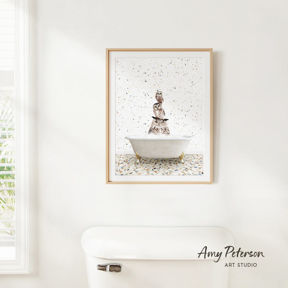 a framed painting of a bird sitting on a bathtub, with a white toilet in the foreground.