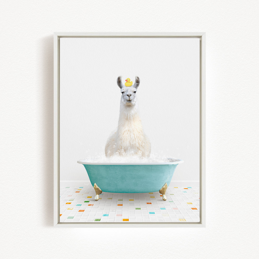 A white llama sitting in a blue bathtub filled with bubbles, with a yellow rubber duck floating on its head.