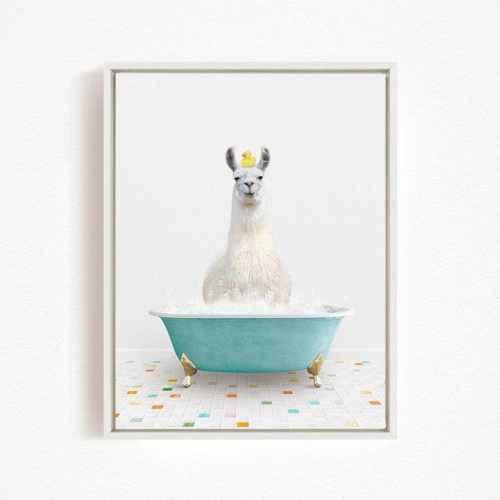 A white llama sitting in a blue bathtub filled with bubbles, with a yellow rubber duck floating on its head.