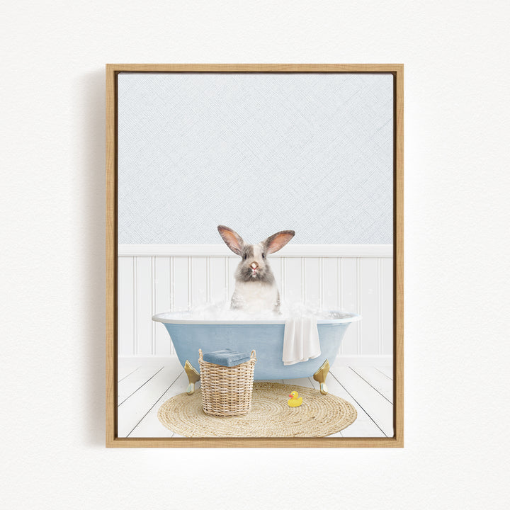 A white rabbit sitting in a blue bathtub filled with water, surrounded by a yellow rubber duck and a woven basket.