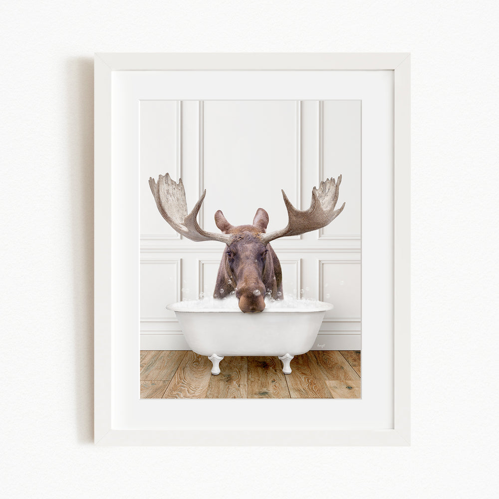 A moose with large antlers is sitting in a white bathtub, appearing to enjoy the bath.