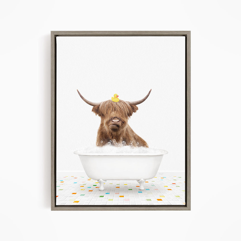 A brown cow with long horns is sitting in a white bathtub filled with bubbles, with a rubber duck perched on its head.