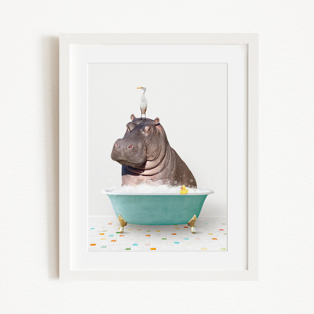 A framed image depicting a hippopotamus sitting in a bathtub, with a bird perched on its head.