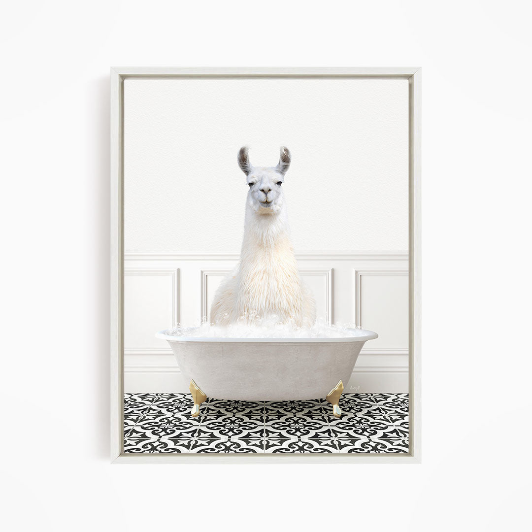 A white llama sitting in a white bathtub filled with bubbles, surrounded by a black and white patterned floor.