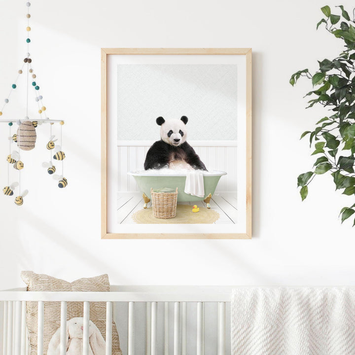A framed image of a panda bear sitting in a bathtub, surrounded by various objects such as a basket and a plant, in a nursery setting.