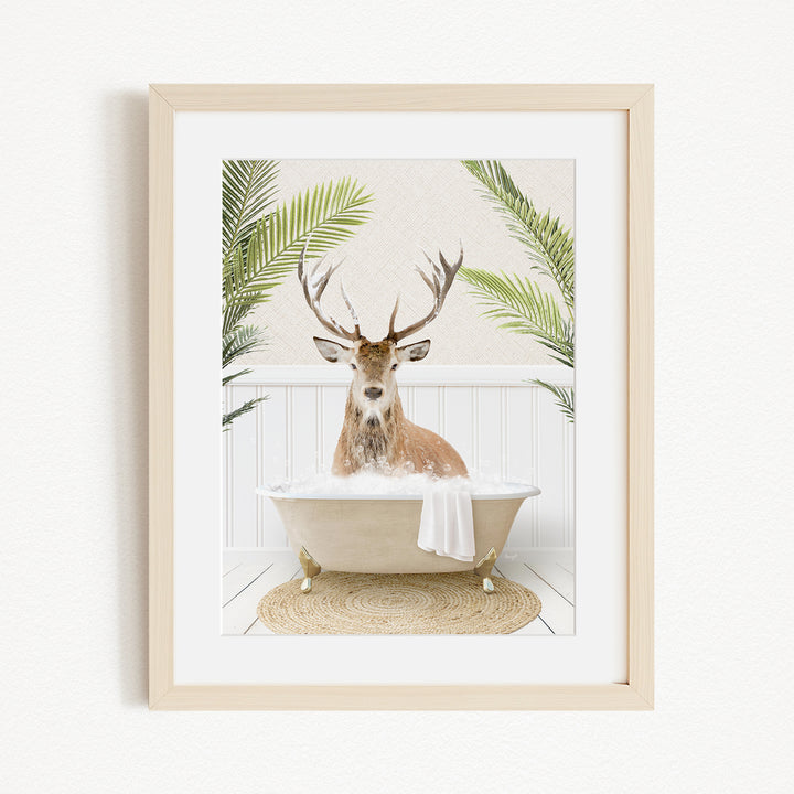 A deer with antlers is sitting in a bathtub filled with bubbles, surrounded by green plants.