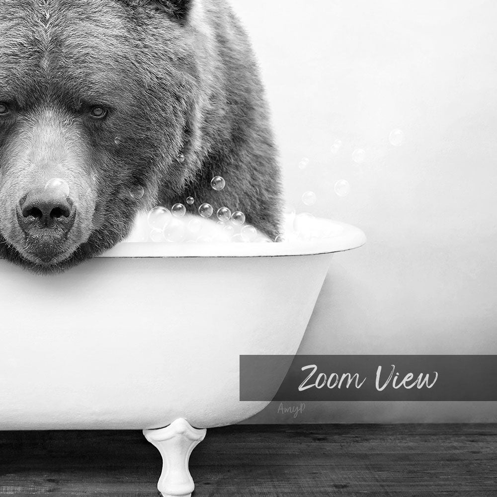 A black and white image of a bear sitting in a bathtub filled with bubbles.