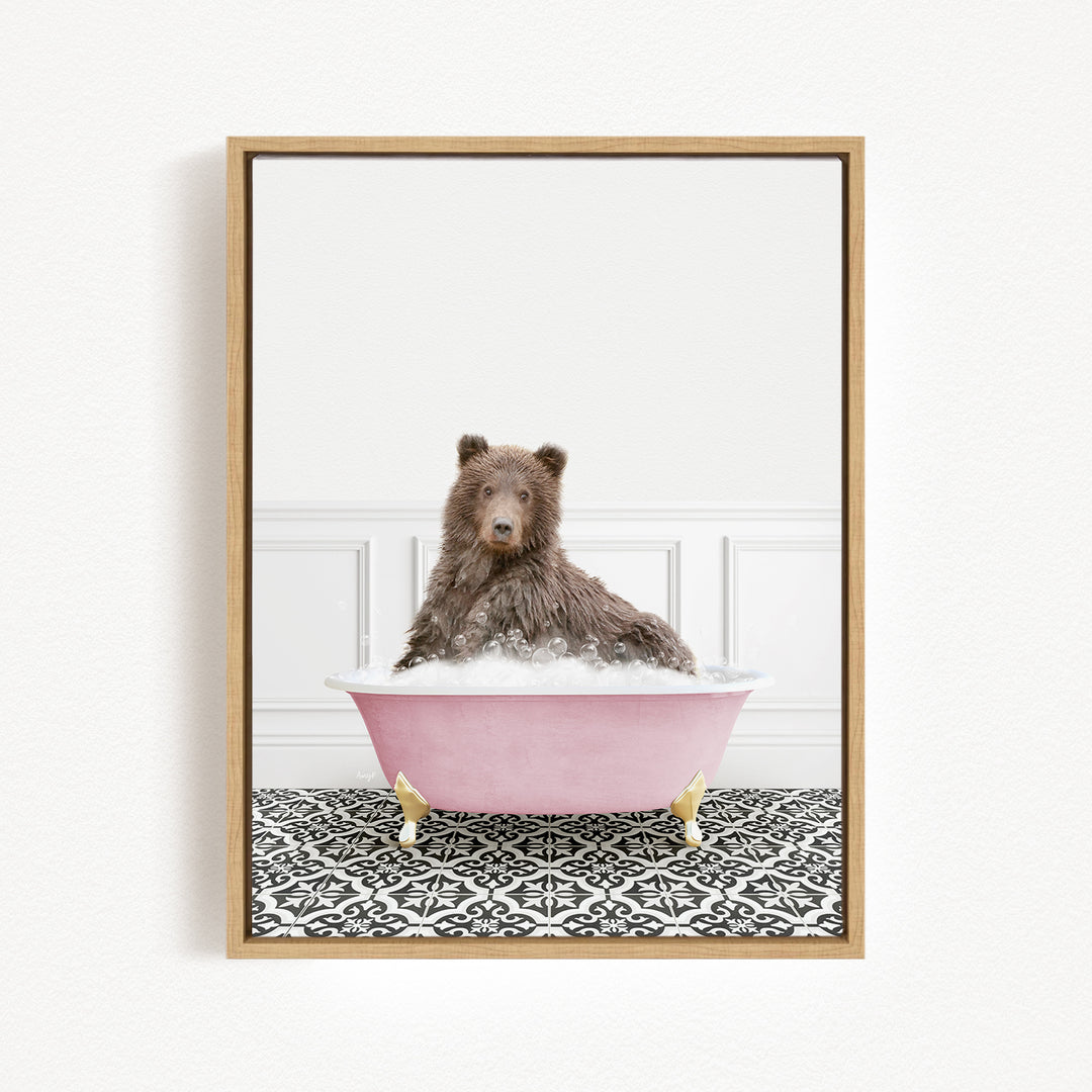 A brown bear sitting in a pink bathtub filled with bubbles, surrounded by a black and white patterned floor.