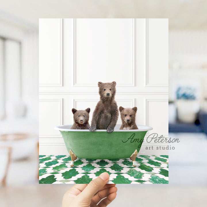 a hand holding a card with three bears in a bathtub