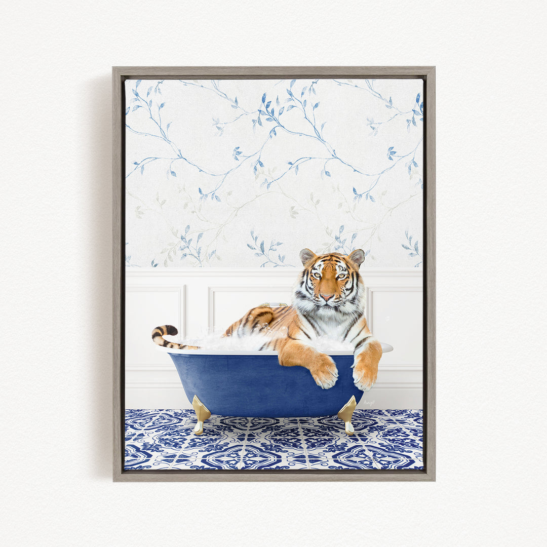 A tiger is sitting in a blue bathtub, surrounded by a patterned blue and white rug.