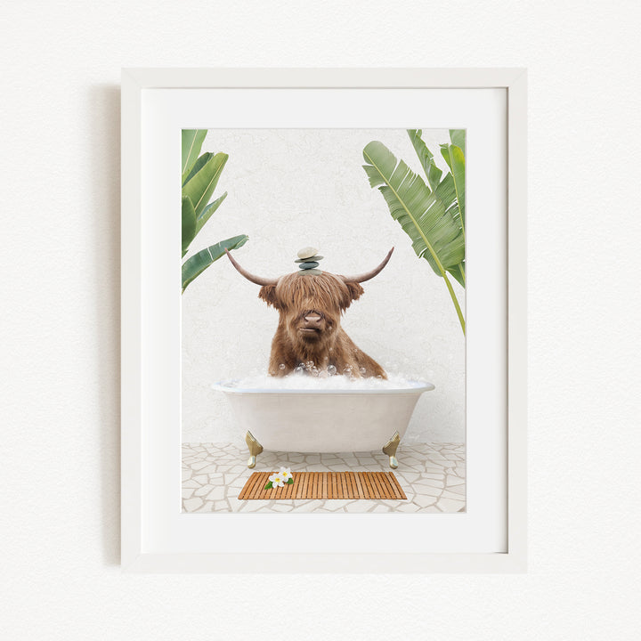 A brown cow with horns is sitting in a white bathtub filled with water, surrounded by green plants and a wooden mat on the floor.