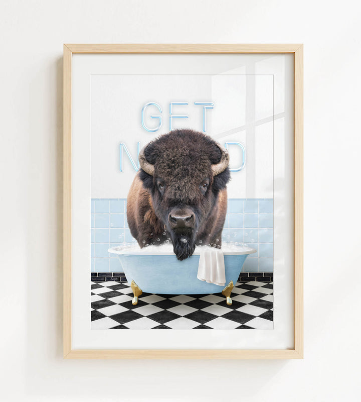 A buffalo is sitting in a bathtub filled with water, with the words "GET NICKED" written on the wall behind it.