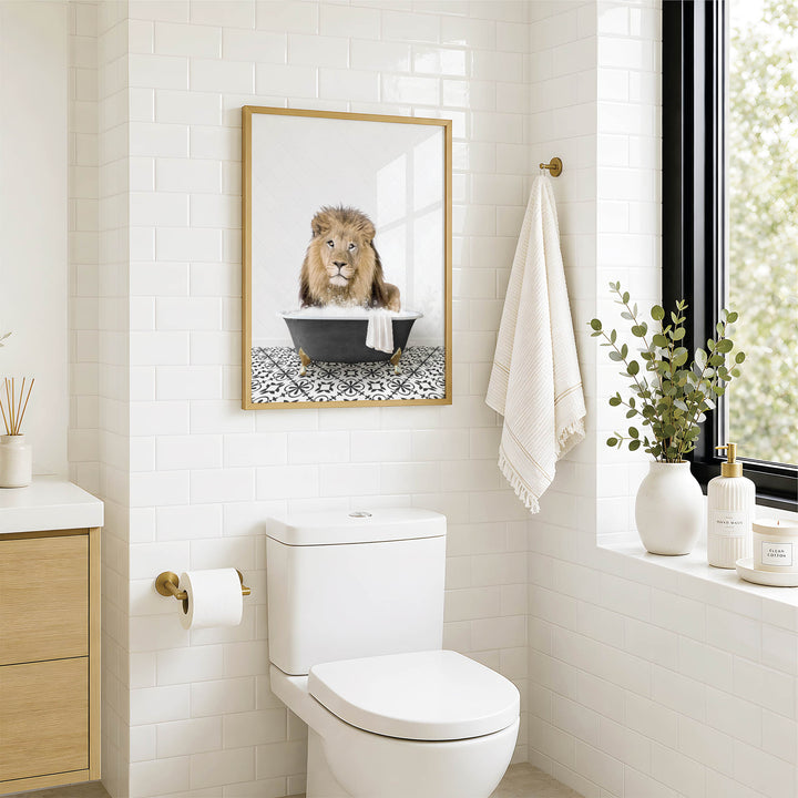 A framed image of a lion sitting in a bathtub is displayed on the wall above a white toilet in a bathroom.