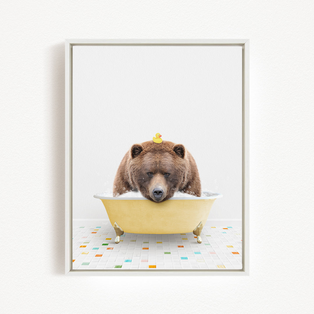 A brown bear is sitting in a yellow bathtub, with a rubber duck perched on its head.