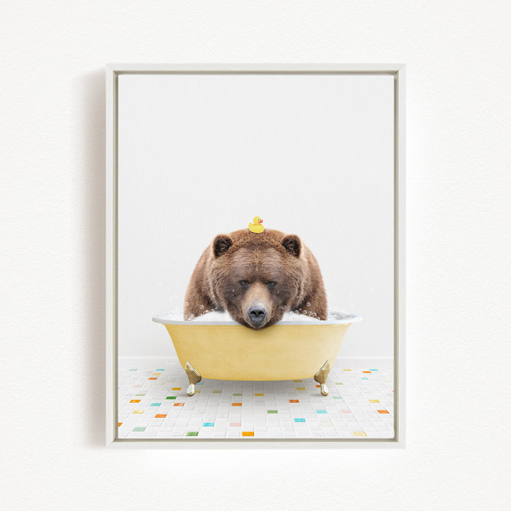 A brown bear is sitting in a yellow bathtub, with a rubber duck perched on its head.
